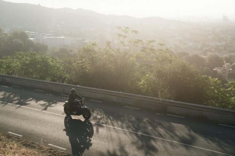 Biker on highway mountain road doing his moto trip on vintage bike in the morning